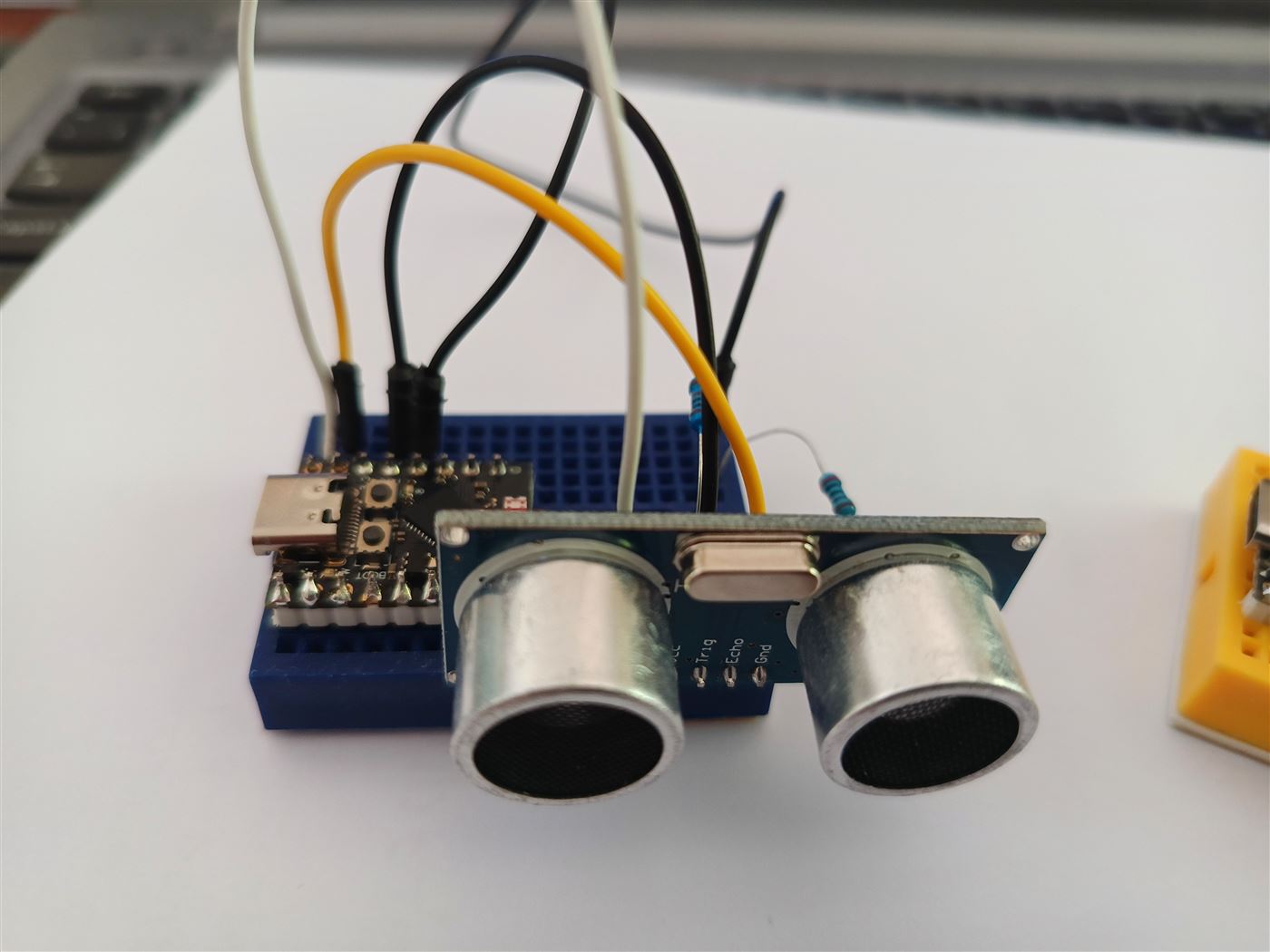 ESP32-C3 on a blue mini breadboard wired to an HC-SR04 ultrasonic sensor